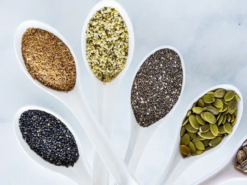 Alimentación saludable: cucharas con diferentes semillas como chia, lino o pipas de calabaza